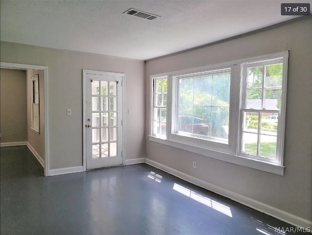 spare room with a textured ceiling and a healthy amount of sunlight