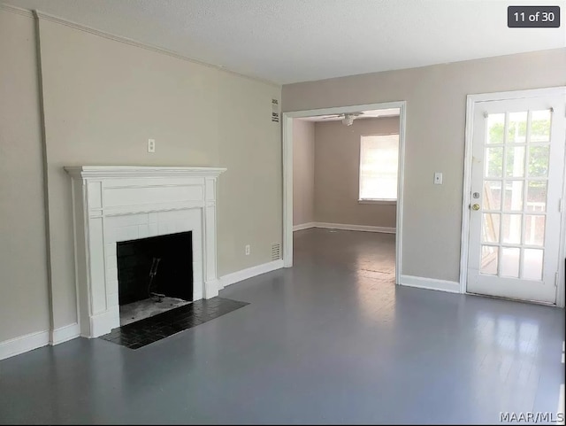 unfurnished living room featuring ceiling fan and a textured ceiling