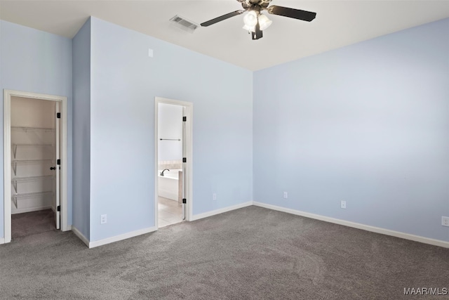 unfurnished bedroom with a walk in closet, carpet flooring, ceiling fan, and a closet