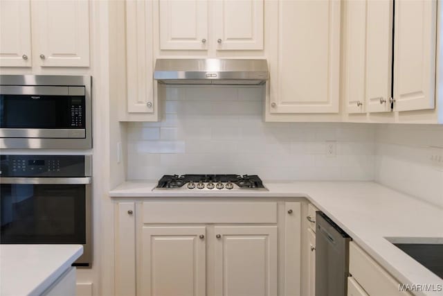 kitchen with range hood, stainless steel appliances, tasteful backsplash, light countertops, and white cabinetry