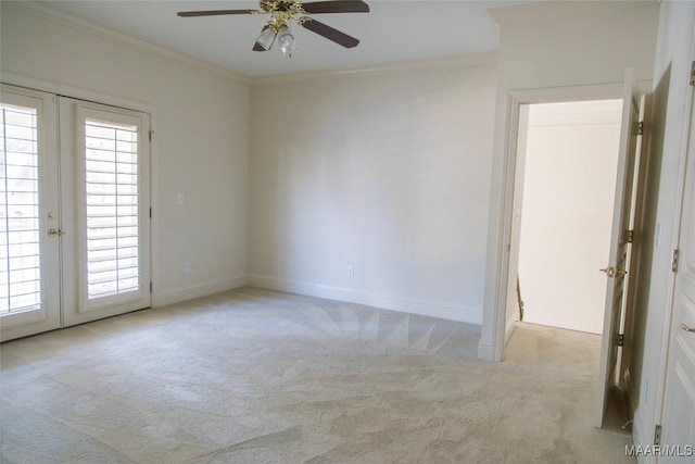 empty room with baseboards, ornamental molding, carpet flooring, and french doors