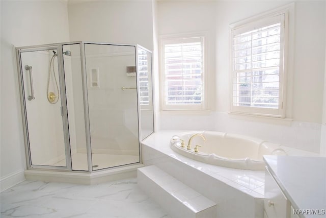 bathroom featuring marble finish floor, a garden tub, and a wealth of natural light