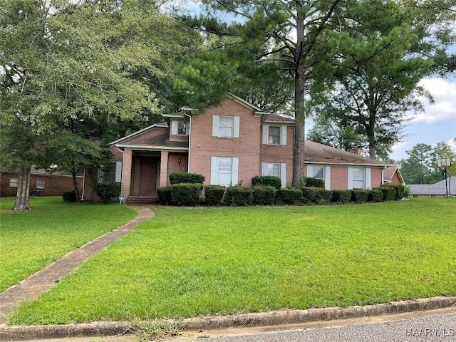 view of front of home featuring a front lawn and brick siding
