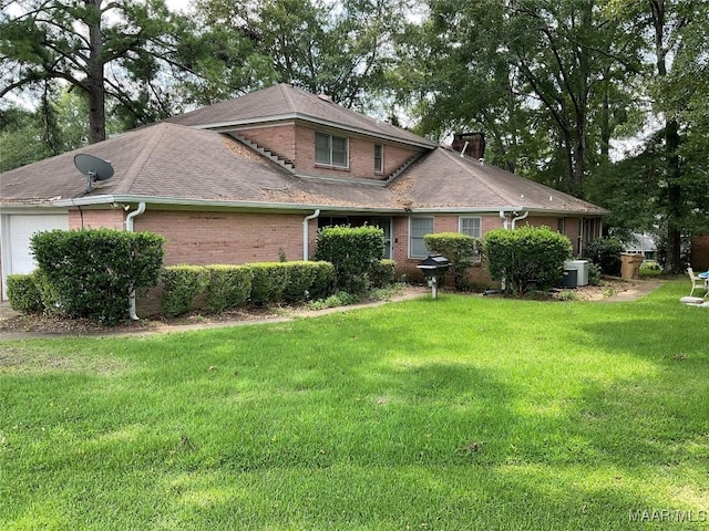 view of front facade featuring a front yard, brick siding, central AC, a chimney, and an attached garage