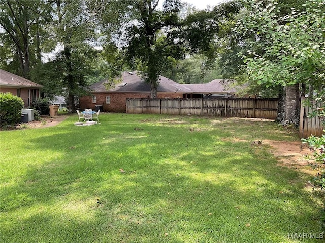view of yard featuring fence and central AC unit