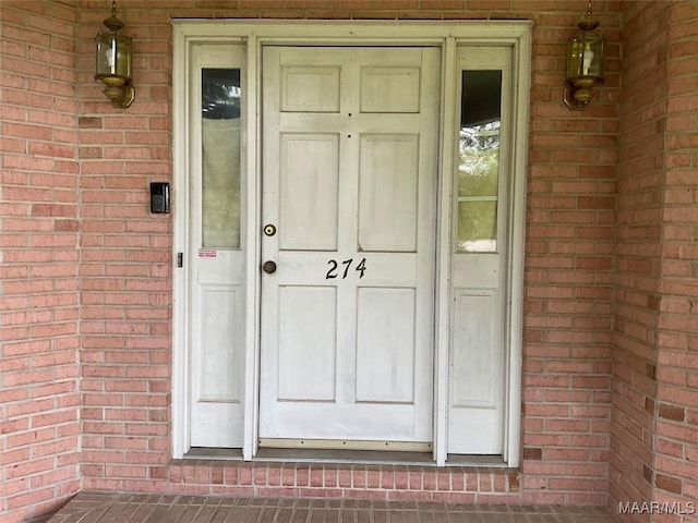 entrance to property featuring brick siding
