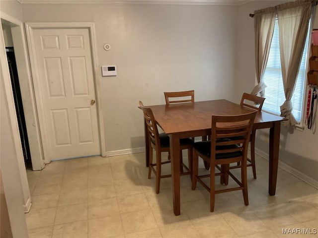 dining room with crown molding and baseboards