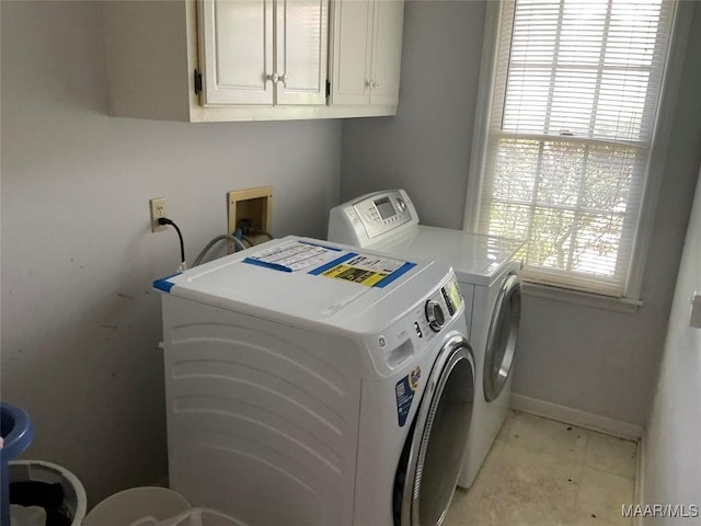 laundry room with separate washer and dryer, cabinet space, and baseboards