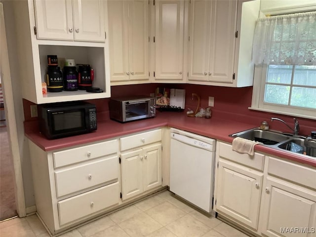 kitchen featuring black microwave, dishwasher, white cabinets, and a sink