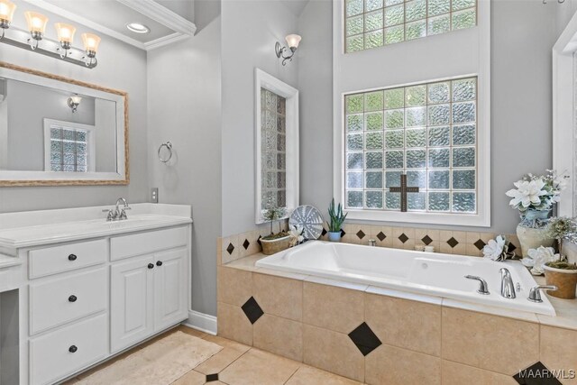 bathroom with tile patterned flooring, tiled bath, and vanity