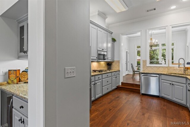 kitchen with sink, dark wood-type flooring, tasteful backsplash, gray cabinetry, and stainless steel appliances