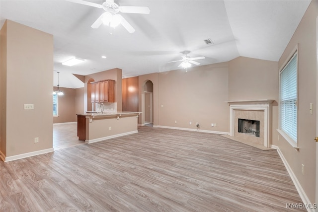 unfurnished living room featuring a fireplace, ceiling fan, and light hardwood / wood-style floors