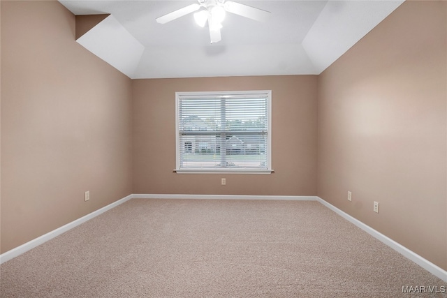 carpeted spare room with ceiling fan and vaulted ceiling