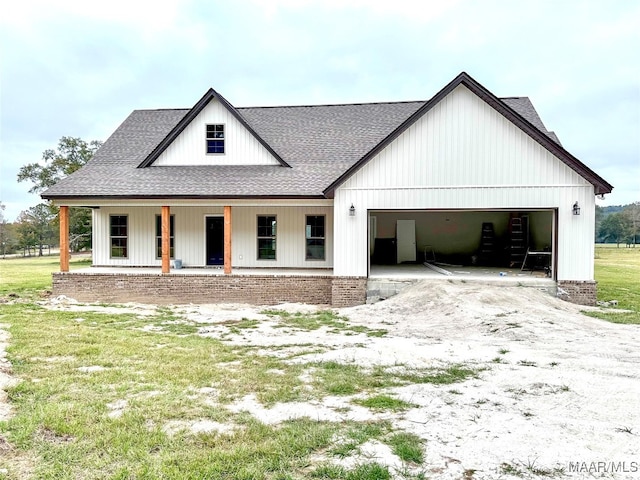 modern inspired farmhouse featuring a front yard, a garage, and a porch