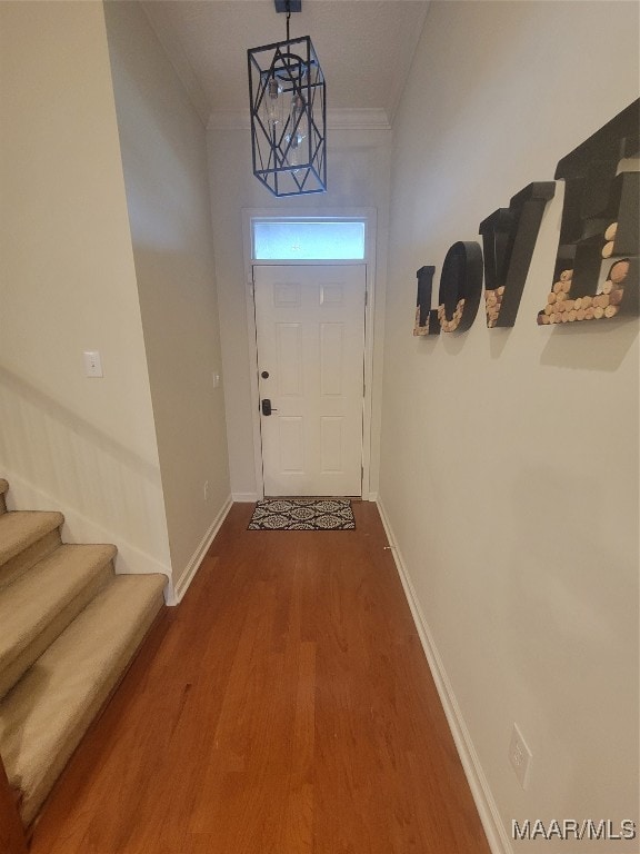 doorway to outside with hardwood / wood-style floors and ornamental molding