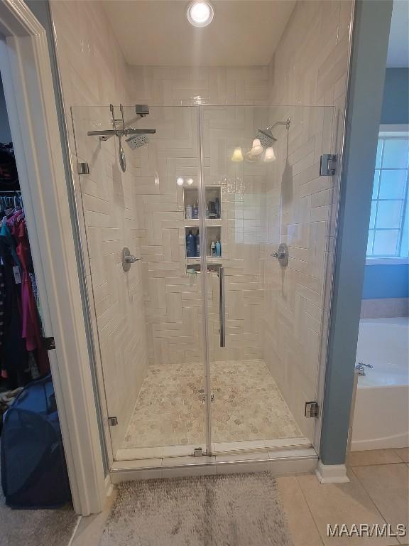 bathroom with tile patterned floors and independent shower and bath