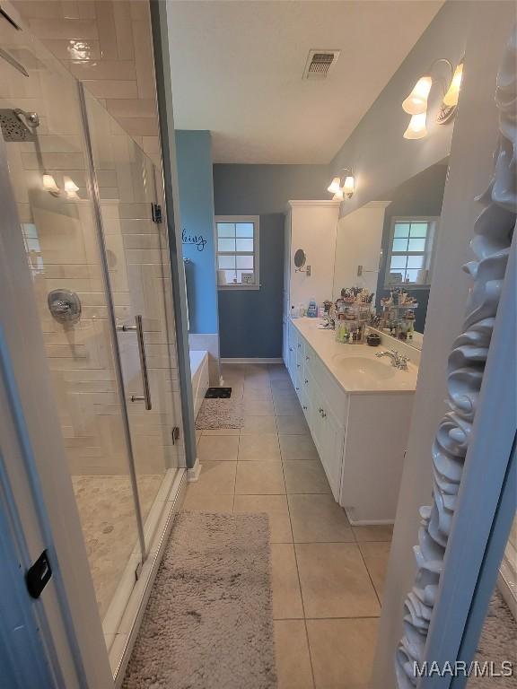 bathroom with tile patterned flooring, vanity, and independent shower and bath