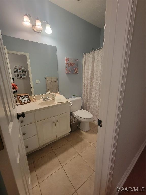 bathroom featuring tile patterned floors, vanity, and toilet