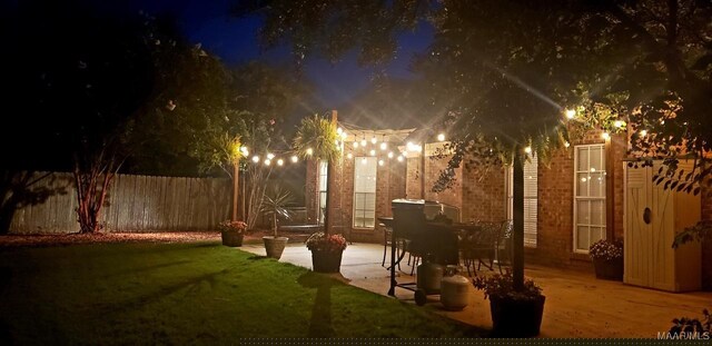 yard at night with a patio area