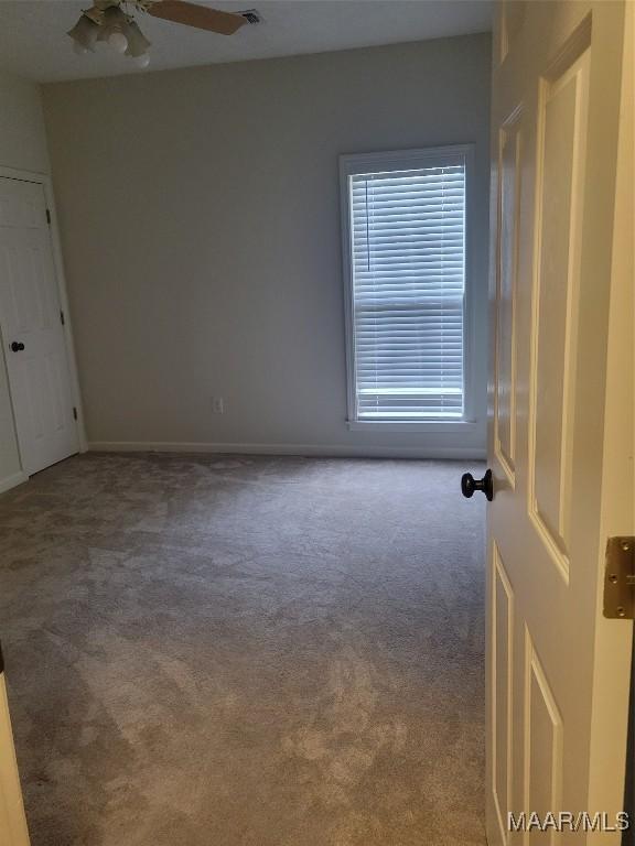 carpeted empty room with ceiling fan and a healthy amount of sunlight