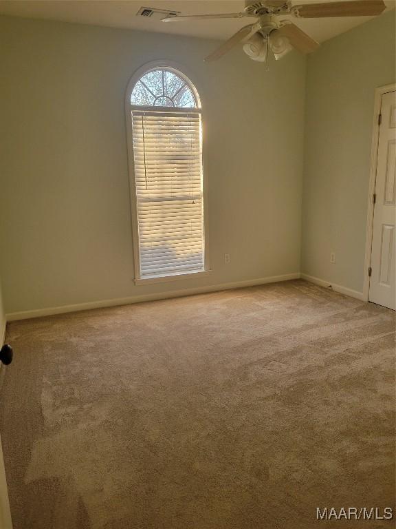 spare room with light carpet and ceiling fan