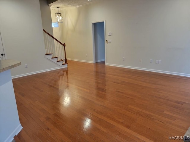 1315 Richton Rd, Montgomery, AL 36117 - unfurnished living room featuring a chandelier, hardwood / wood-style floors, stairway, and baseboards