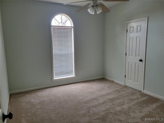 carpeted spare room featuring ceiling fan