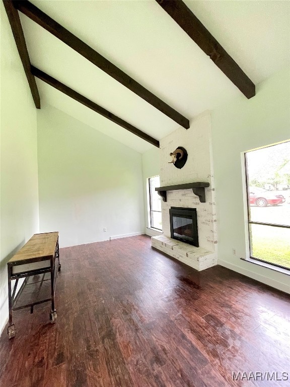 unfurnished living room with a healthy amount of sunlight, wood-type flooring, and a brick fireplace