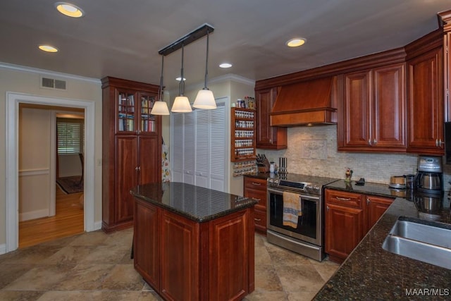 kitchen with visible vents, stainless steel electric range, premium range hood, pendant lighting, and backsplash