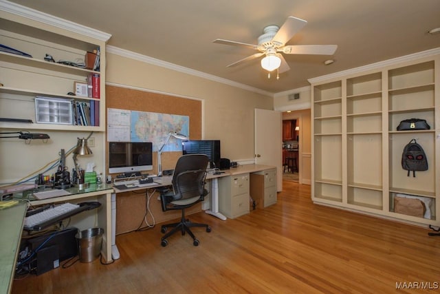 office area with ornamental molding, light wood-type flooring, and visible vents