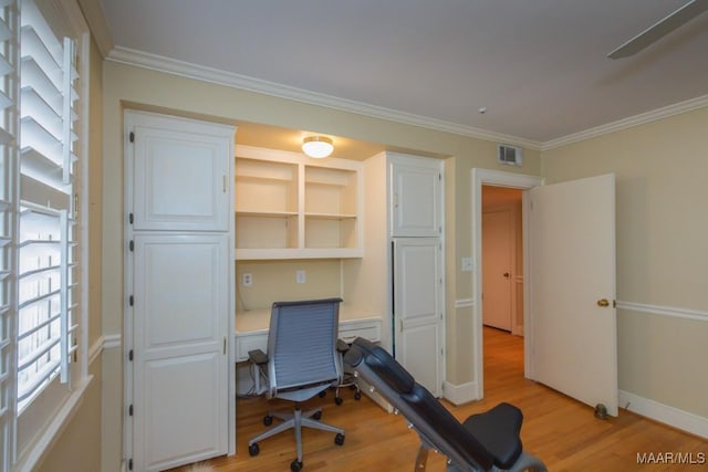 office featuring ornamental molding, light wood-type flooring, visible vents, and baseboards