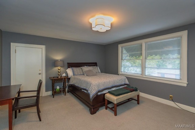 bedroom featuring light colored carpet and baseboards