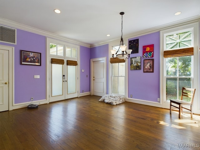 unfurnished dining area with an inviting chandelier, ornamental molding, dark hardwood / wood-style flooring, and french doors