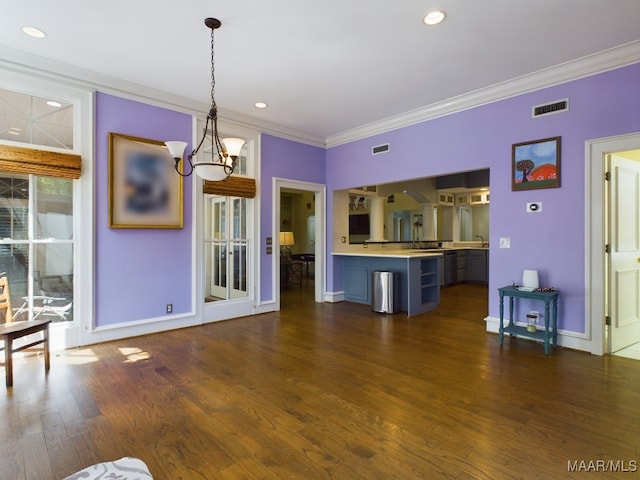 unfurnished living room featuring crown molding, dark hardwood / wood-style floors, and a chandelier