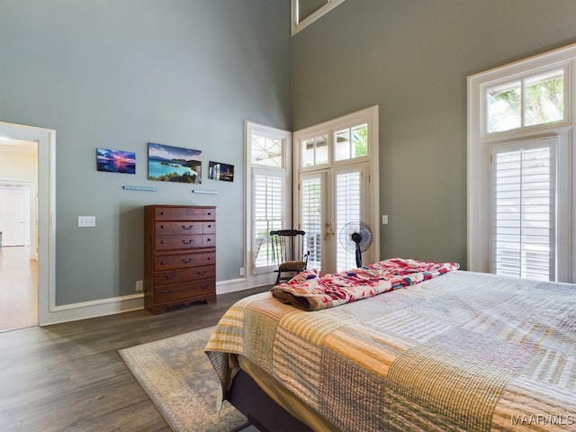 bedroom featuring a high ceiling and dark hardwood / wood-style floors