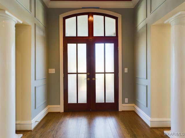 entrance foyer with french doors, ornamental molding, decorative columns, and hardwood / wood-style floors