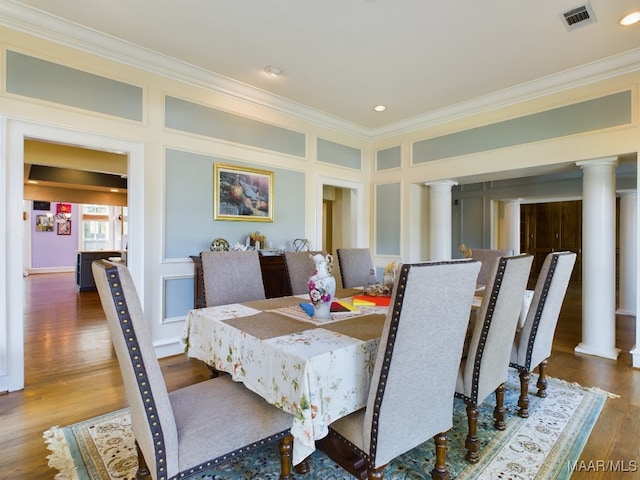 dining space with ornamental molding, dark wood-type flooring, and decorative columns