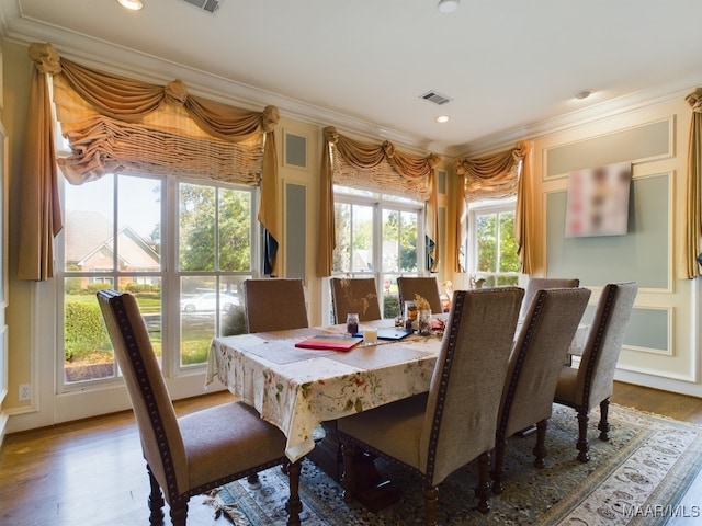 dining area with ornamental molding and hardwood / wood-style floors