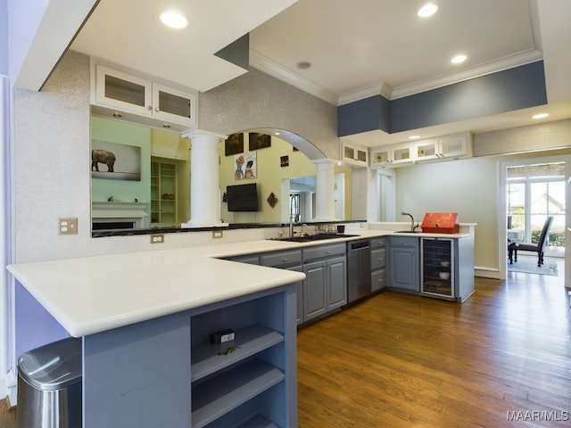 kitchen with gray cabinets, wine cooler, dark wood-type flooring, decorative columns, and kitchen peninsula