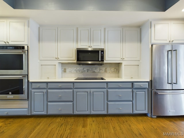 kitchen with white cabinets, stainless steel appliances, dark hardwood / wood-style flooring, and gray cabinetry