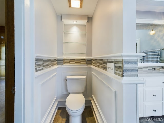 bathroom featuring hardwood / wood-style flooring, toilet, and decorative backsplash