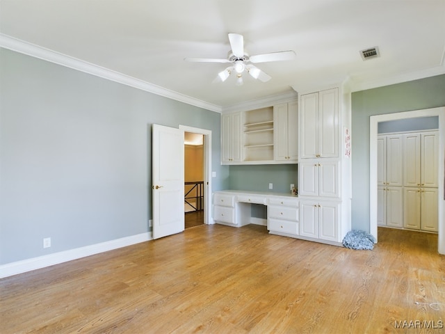 unfurnished living room with light hardwood / wood-style flooring, built in desk, ceiling fan, and ornamental molding