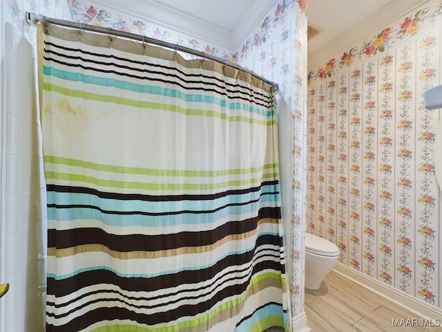 bathroom with ornamental molding, hardwood / wood-style flooring, toilet, and curtained shower