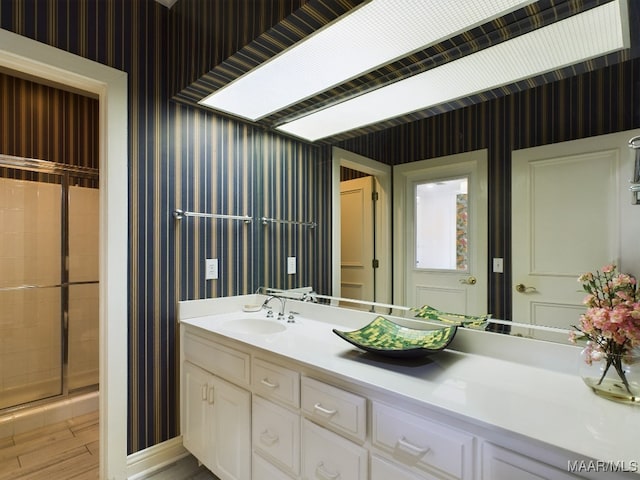 bathroom featuring hardwood / wood-style floors, walk in shower, and vanity