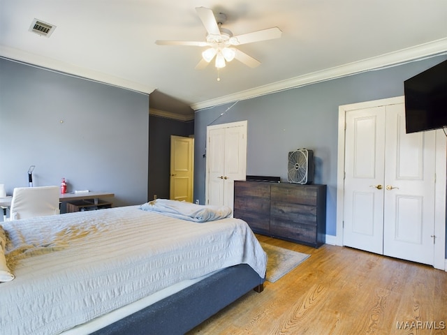 bedroom with ornamental molding, light wood-type flooring, and ceiling fan