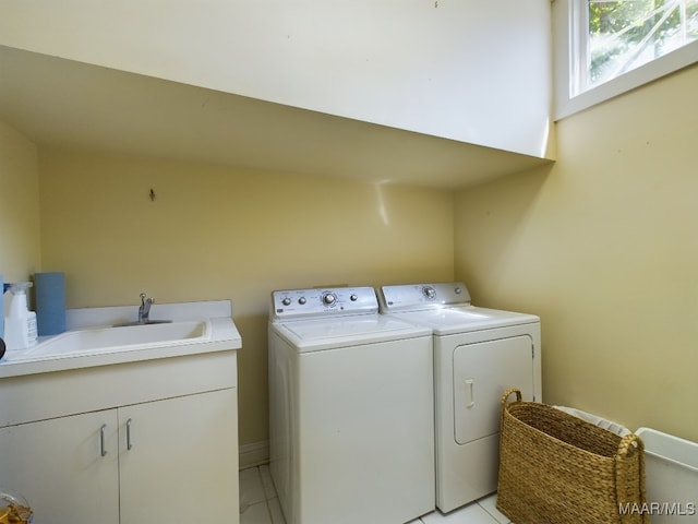 washroom featuring washer and clothes dryer, light tile patterned flooring, sink, and cabinets