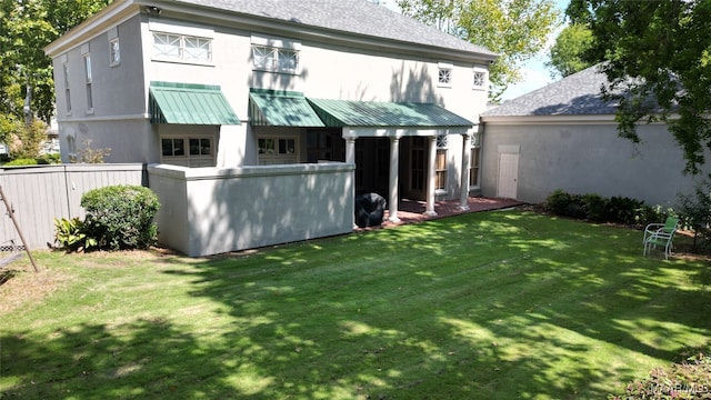 rear view of property with a lawn