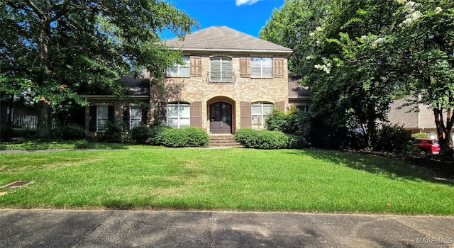 colonial inspired home featuring a front lawn