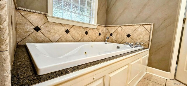 bathroom with tile patterned floors and a washtub