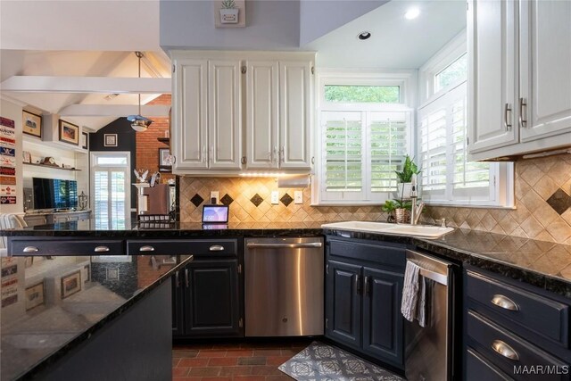 kitchen featuring beamed ceiling, tasteful backsplash, dark stone countertops, and dishwasher